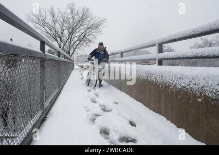 Chicago, USA. 9. Januar 2024. Chicago Wetter : Ein Radfahrer spaziert mit seinem Fahrrad, während in den westlichen Vororten Chicagos starker Schnee fällt. Am Ende der Woche wird noch mehr Schnee erwartet, bevor die Temperaturen von -14 °C und darunter deutlich kälter werden. Quelle: Stephen Chung / Alamy Live News Stockfoto