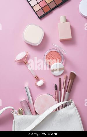 Trendige pinke Make-up-Werkzeuge auf rosa Hintergrund: Make-up-Pinsel, Lidschatten, Rouge. Das Konzept verschiedener weiblicher Zubehörteile. Weibliche Alltagskosmetik Stockfoto