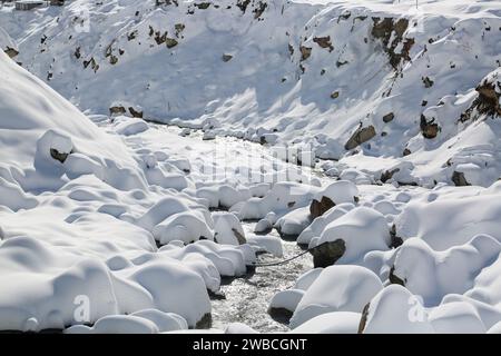 Schneebedeckte Flussufer und Steine im Himalaya. Uttarakhand ist bekannt für seine langen Bergketten und glitzernden Juwelen auf der Weltkarte Stockfoto