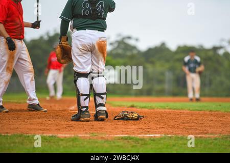 Baseballspiel, Catcher steht auf und Cathers Maske liegt während des Baseballspiels auf dem Boden. Stockfoto