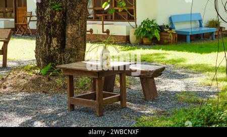 Zwei bemalte Stühle im Freien auf einem üppigen Garten. Holzstuhl und Tisch im Garten. Ein Ort zum Entspannen und Entspannen im Sommergarten. Stockfoto