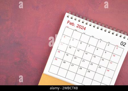 Schreibtischkalender Februar 2024 auf rotem Hintergrund. Stockfoto