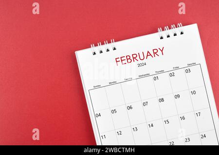 Schreibtischkalender Februar 2024 auf rotem Hintergrund. Stockfoto