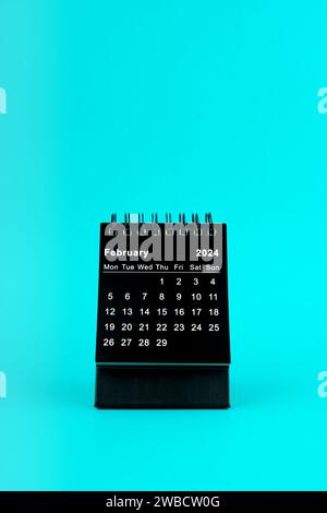 Schwarzer Kalender für Februar 2024. Desktop-Kalender auf grünem Hintergrund. Stockfoto