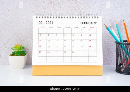 Februar 2024 Schreibtischkalender mit Holzstift auf weißem Tisch. Stockfoto