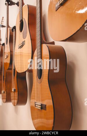 Nahaufnahme mehrerer spanischer Gitarren, die an der Wand hängen, nach einem Musikkurs Stockfoto