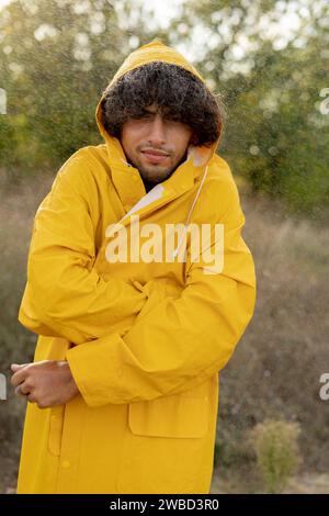 Porträt eines arabischen Mannes in gelbem Regenmantel, der im Herbstregen gefriert Stockfoto