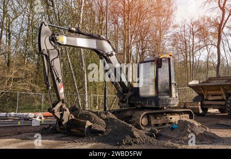 Bagger, der halbtrockene Betonmischung auf der Baustelle in den Kipper lädt Stockfoto