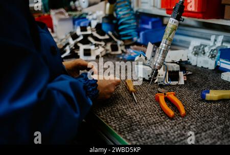 Elektriker bei der Arbeit, der die Kabelverbindung der Hochspannungsleitung in der Sicherungstafel der industriellen Verteilerverteilung überprüft. Stockfoto