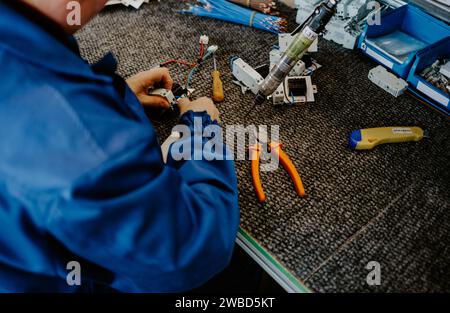 Elektriker bei der Arbeit, der die Kabelverbindung der Hochspannungsleitung in der Sicherungstafel der industriellen Verteilerverteilung überprüft. Stockfoto