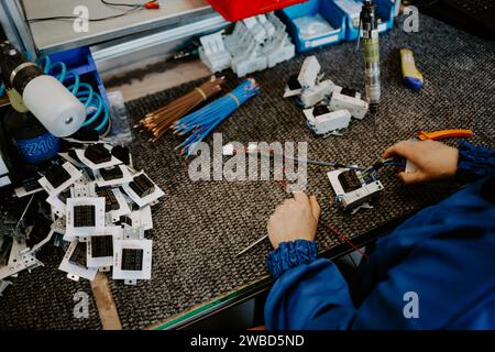 Elektriker bei der Arbeit, der die Kabelverbindung der Hochspannungsleitung in der Sicherungstafel der industriellen Verteilerverteilung überprüft. Stockfoto