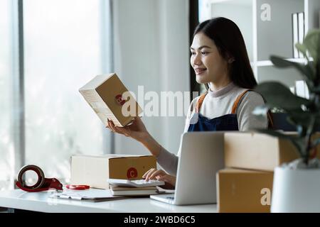 Junge Geschäftsfrau Unternehmerin Online-Versandunternehmen bereitet Pakete vor, die an Kunden gesendet werden. E-Commerce-Konzept Stockfoto