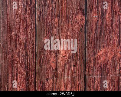 Alte rote Holzwand mit abblätternder Farbe Stockfoto