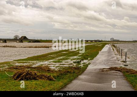 Werkendam, Niederlande, 29. Dezember 2024: Wasser überquert den Treshold zwischen dem Fluss und den Nebenkanälen als Teil des Saals for the ri Stockfoto