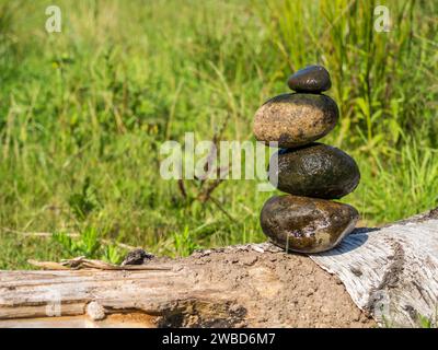 Balance Steine auf einer Bank mit einer Wiese Stockfoto