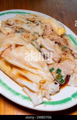 Traditionelle kantonesische Gerichte wie Cheong Fun oder Reisnudelrollen oder gedämpfte Vermicelli-Brötchen, vertikale Komposition Stockfoto