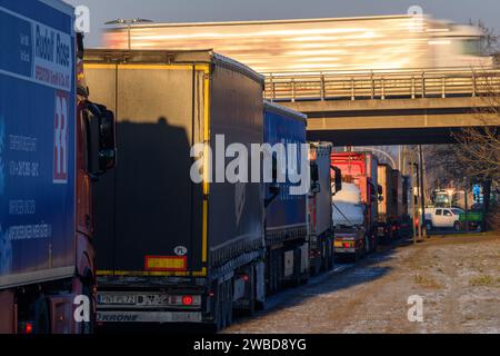 Magdeburg, Deutschland. Januar 2024. Vor der abgesperrten Autobahnausfahrt Magdeburg-Rothensee stauen Lkw in Richtung Hannover. Die Blockaden der Bauern auf der Autobahn A2 begannen um 09:00 Uhr morgens. Die Blockaden werden alle 30 Minuten geöffnet, damit der Verkehr durchrollt. Der Bauernverband hat eine Woche lang als Reaktion auf die Sparpläne der Bundesregierung gefordert. Am 15. Januar 2024 findet in Berlin eine große Demonstration statt. Quelle: Klaus-Dietmar Gabbert/dpa/Alamy Live News Stockfoto