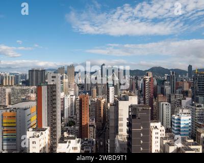 12. November 2023 Kowloon - Hong Kong: Stadtbild von Hong Kong City am Morgen mit dichten Wolkenkratzern und blauem Himmel Stockfoto