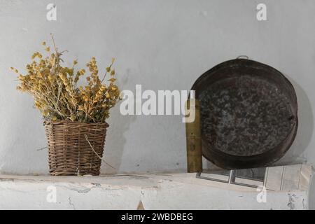 220 Set Hausdekoration in einem osmanischen Haus der frühen 1700er Jahre= Eisenkraut Blumen in Korb, Messing Kaffeemühle und Eisenpfanne. Gjirokaster-Albanien. Stockfoto