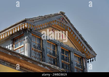 224 gelbe Fassade eines Hauses im osmanischen Stil mit eisernen Fenstern und üppiger Holzdekoration, Altstadt-Palorto-Viertel. Gjirokaster-Albanien. Stockfoto