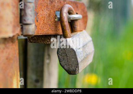 Altes Vorhängeschloss symbolisch am Zaun Stockfoto