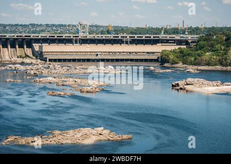 Blick auf die Turbinenhalle von DNIPROGES-2 des Wasserkraftwerks Dnieper und die Felsen in der Nähe nach der Zerstörung des Kakhovka-Damms Stockfoto