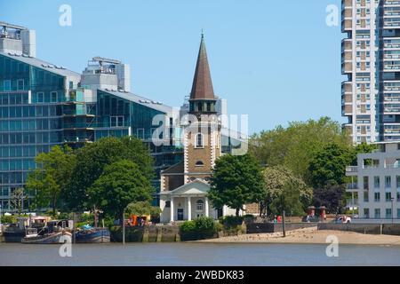 Battersea's Schönheit: Die Pracht der St. Mary's Church spiegelt sich im Wasser der Themse wider, mit einem Hauch von Drama am Himmel. Stockfoto