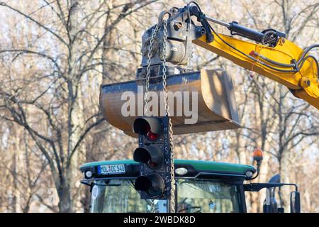 Bauernproteste vor dem Brandenburger Tor in Berlin, Deutschland - 8,12023: An einer Baggerschaufel hängt eine Verkehrsampel, welche die Ampel-Regierung symbolisieren soll mit dem Schriftzug muss weg während Bauern protestieren mit ihren Traktoren vor dem Brandenburger Tor gegen Subventionskürzungen. Berlin Stockfoto