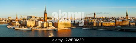 Großes, detailliertes Panorama der Altstadt von Stockholm mit Riddarholmen, im Winter mit Schnee und Morgensonne. Gelbe Farben, blauer Himmel, kaltes Wetter. Stockfoto