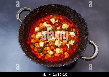 Knusprig gegrillter Feta mit sautigen Butterbohnen in der Pfanne Stockfoto