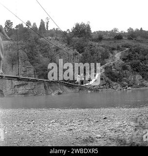 Vrancea County, Rumänien, ca. 1977. Die Hängebrücke über den Fluss Putna verbindet die Dörfer Poduri und Colacu. Stockfoto