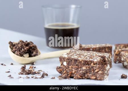 Dresden, Deutschland. Januar 2024. Cashew-Dattelriegel liegen auf Backpapier vor einem Glas Kaffee. Quelle: Sebastian Kahnert/dpa/Alamy Live News Stockfoto