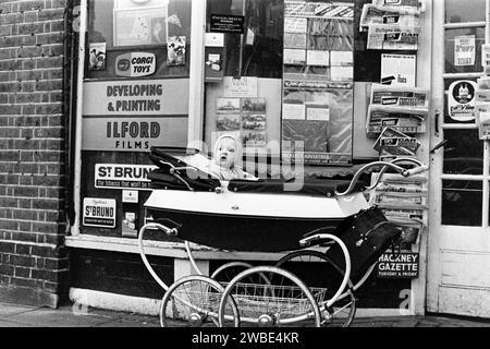Ein Baby wurde in einem Kinderwagen vor Souch's Zeitungskiosk, Tobacconist & Post Office, Lordship Lane, Tottenham, London, gelassen - Mittwoch, 8. Januar 1969 Stockfoto