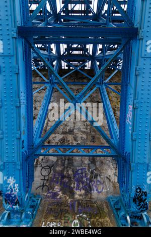 Foto von Graffiti-Kunstwerken auf Beton. Das ist unter einer Eisenbahnbrücke aus Metall Stockfoto