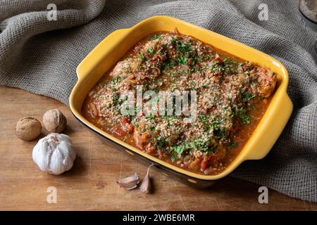 Chakhokhbili mit Hühnchen und Gemüse georgianische Küche mit Blick auf den alten Holztisch. Nüsse und Knoblauch Stockfoto