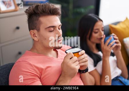 Mann und Frau, ein lächelndes Paar, das zu Hause auf dem Sofa sitzt Stockfoto