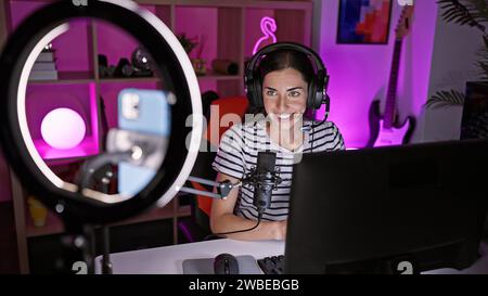 Die wunderschöne junge hispanische Gamerin streamt ihren epischen Spielabend, spielt freudig Videospiele und macht interaktive Videoanrufe von ihrem Spieleabend Stockfoto