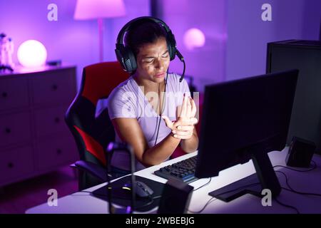 Junge schöne hispanische Frau Streamer betonte mit Computer im Spielzimmer Stockfoto