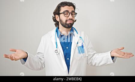 Ein junger hispanischer Arzt, der keine Ahnung hat über isolierten weißen Hintergrund Stockfoto