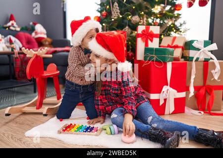 Entzückender Junge und Mädchen, die sich küssen und umarmen und weihnachten zu Hause feiern Stockfoto