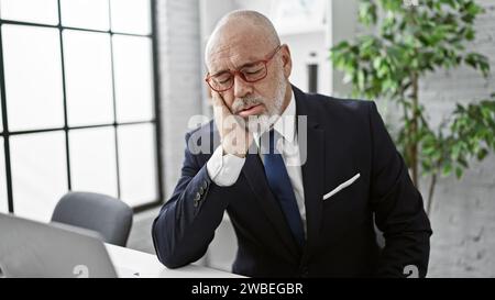 Geschäftsmann mit Bartgefühl in einer modernen Büroumgebung. Stockfoto