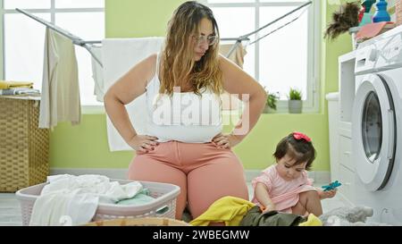 Mutter und Tochter, verbunden durch Liebe, Teamarbeit bei der Hausarbeit zu Hause, gemeinsame Arbeit, Konzentration auf Baby während der Wäscherei. Stockfoto