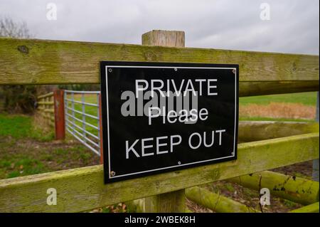 Schwarz-weiß Privat bitte halten Sie das Schild auf einem Holzzaun in einer ländlichen Umgebung. Stockfoto