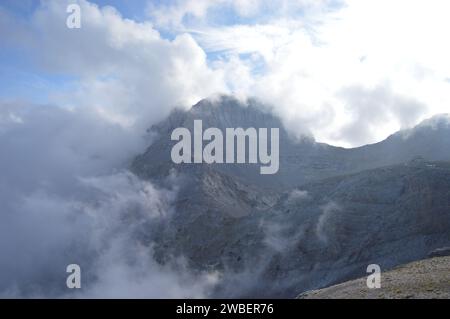 Blick auf die von Wolken bedeckten Stefani und Mytikas (Olymp-Gipfel). Das Foto wurde in der Nähe des Muses Plateau aufgenommen. Stockfoto