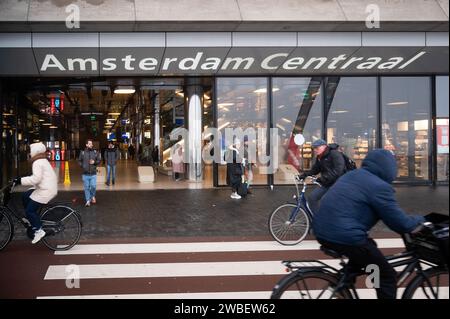 Pendler fahren an einem kalten, nebeligen Morgen am Bahnhof Amsterdam Centraal auf Radwegen zur Arbeit Stockfoto