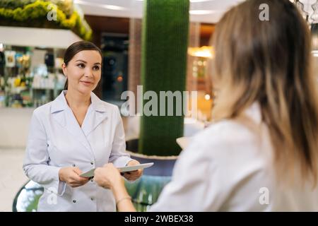 Zwei Ärzte arbeiten zusammen an der Patientenakte im Krankenhaus. Die Krankenschwester, die während der Arbeit in der medizinischen Klinik Klemmbrett gibt. Ärztin mit Diskussion Stockfoto