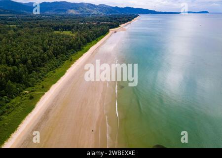 Blick aus der Vogelperspektive auf einen großen, leeren tropischen Strand, umgeben von üppigem Grün Stockfoto