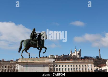 Lyon, Frankreich - 30. Januar 2022: Reiterskulptur des Königs Ludwig XIV. Und die Basilika Fourviere auf dem Hintergrund, Bellecour-Platz in Lyon, Fr. Stockfoto