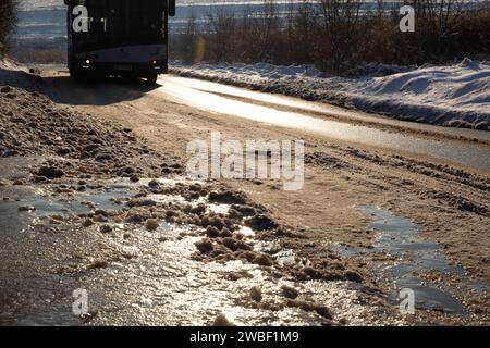 Krakau, Polen, 10. Januar 2024. Ein öffentlicher Bus fährt auf Schnee und Eis in den Vororten von Krakau, während die Temperaturen sanken und der Schnee in Südpolen fiel. Die Straßen in den Vororten werden vernachlässigt. Stockfoto