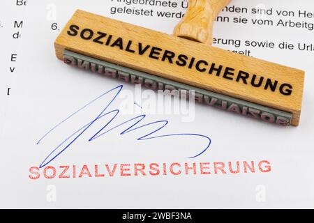 Ein Holzstempel liegt auf einem Dokument. Deutsche Inschrift: Sozialversicherung Stockfoto